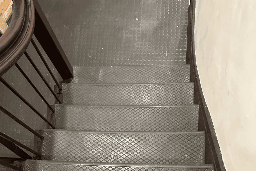 Dull worn rubber staircase flooring before professional buffing and waxing
