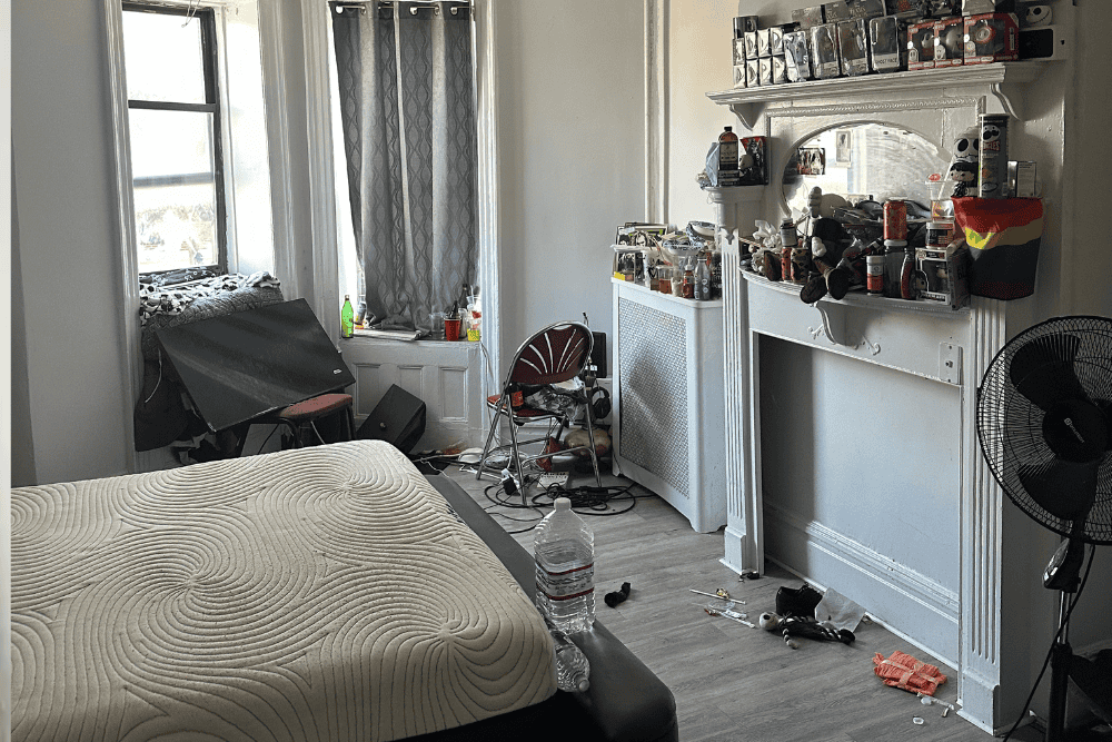 Hoarded cluttered bedroom filled with trash and items before professional anti-hoarding cleanup service